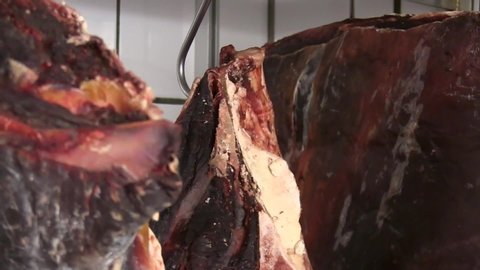Close up of meat hanging on hooks curing in restaurant