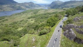 Aerial video of Motor bikes and cars traveling along the renowned 'Ring of Kerry', part of the tourist route 