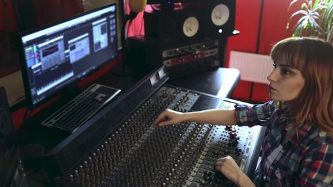 Sound producer working at recording studio using soundboard and monitors Video de stock