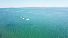 Jet skiing on Lake Huron during the summer in Michigan. Aerial drone footage on a beautiful sunny day.
