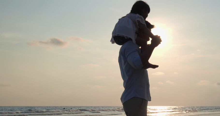 Asian kids riding on neck and shoulder of father on the beach summer. Silhouette of happy family at sunset. Concept of family, travel, silhouettes and kid dream. Parents with children back silhouette. Royalty-Free Stock Footage #1029557366