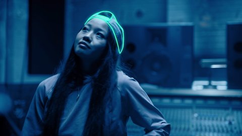 R&B dancer grooving and dancing in her music studio in dark blue light. Hand drawn animation over live action footage in a grunge neon style. Shot on 4k RED camera.
