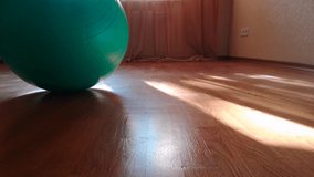 Seamless looped video, close-up: fitness ball on a wooden floor in the studio