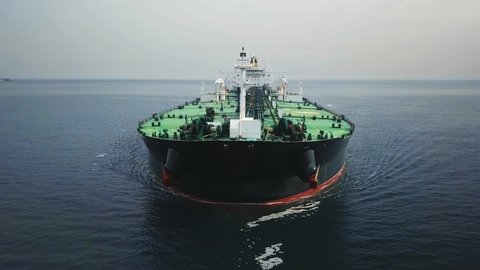 Bow and front deck of a tanker ship underway in the open sea. Aerial frontal view as crude oil tanker ploughs through waters at sea. Full loaded vessel moves at calm waters. Close up of bulbous bow br
