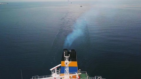 Green deck tanker ship sailing on open sea with pollution. Aerial, flying over. Exhaust emissions from diesel engines comprise nitrogen oxygen carbon dioxide monoxide oxides sulphur hydrocarbon vapour
