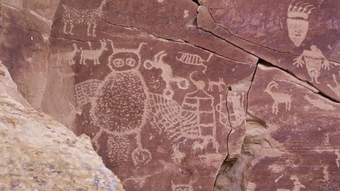 Panning across big petroglyph panel with bear paw with claws and giant owl in Nine Mile Canyon.