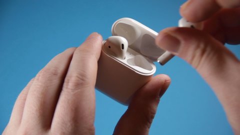 Los Angeles, CA / USA - May 2019:  Open and Close AirPods on Blue Background
