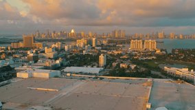 MIAMI, FLORIDA, USA - JANUARY 2019: Aerial drone panorama view flight over Miami beach city centre at sunrise. Streets, hotels, shopping malls and residential buildings from above.