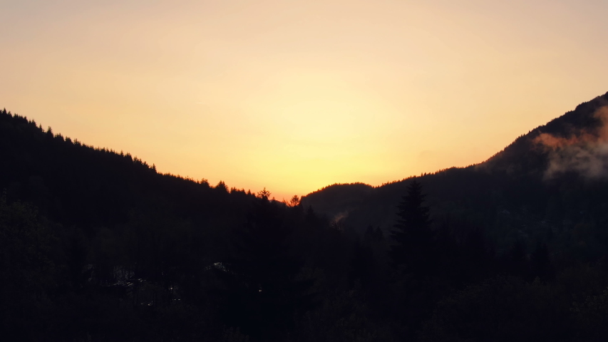 Silhouettes of mountains against the rising sun. Magnificent view in the Alps of Austria at dawn. Dramatic scene. Wonderful world.