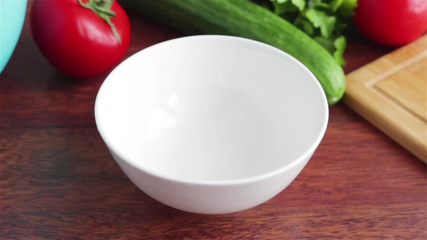 summer fresh salad with sliced cabbage tomaotes radish corn cucumber parsley places in to white bowl