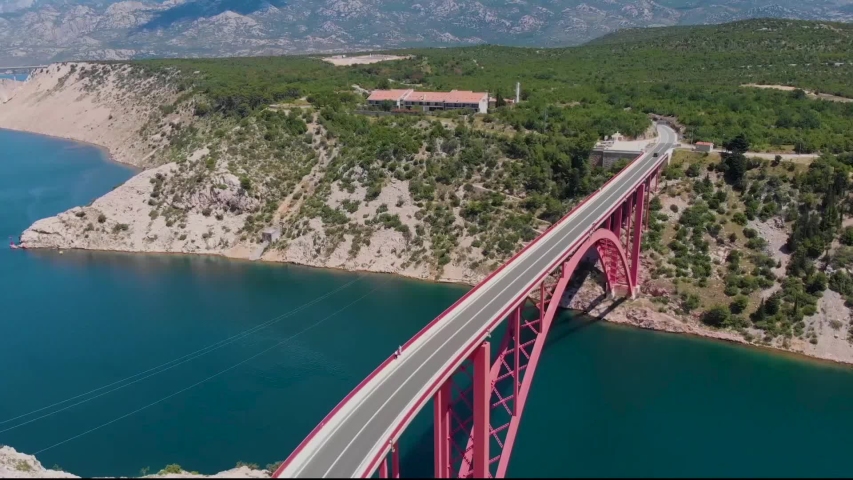 Turning aerial view of a red bridge in a fjord