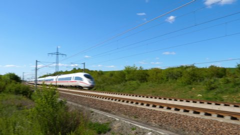 Dauborn, Germany - May 15, 2019: Tracking shot of a passing ICE train on the highspeed line Frankfurt - Cologne near Limburg. ICE is a highspeed train system in Germany