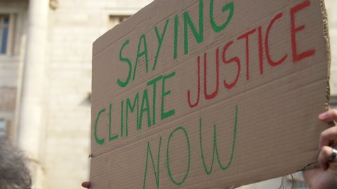 Climate Justice Now poster in a Meeting due Clime Change. Activists in action against the Global Warming