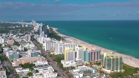 MIAMI, FLORIDA, USA - JANUARY 2019: Aerial drone panorama view flight over Miami beach city centre at sunny day. Streets, hotels, shopping malls and residential buildings from above.