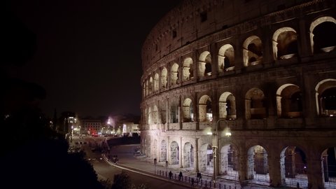 Left to right  shot of night traffic nearby the Colosseo in Rome. The Colosseum also known as the Flavian Amphitheatre, an oval amphitheatre in the centre of the city of Rome