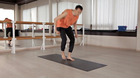 A person practicing advanced yoga. A strong man performing yoga exercises in the Studio