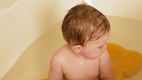 The baby enjoys and rejoices in the water in bathroom, Beautiful Girl Laughing With blue eyes. Slow motion full HD video