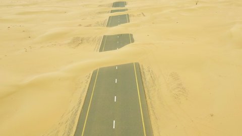 View from above, stunning aerial view of a deserted road covered by sand dunes in the middle of the Dubai desert. Dubai, United Arab Emir 库存视频
