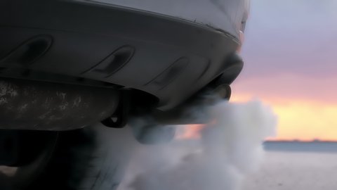 CO2 smoke emissions blowing from SUV truck's muffler exhaust tail pipe 