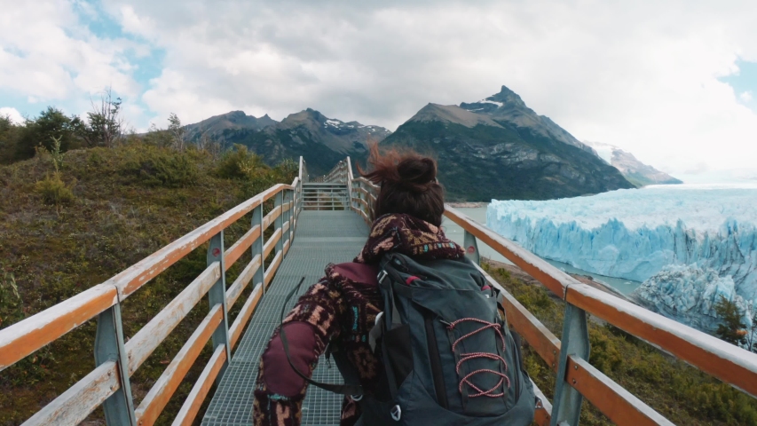 Woman running on the corridor in front of the impressive Glaciar Perito Moreno of the National Park Los Glaciares. 4k