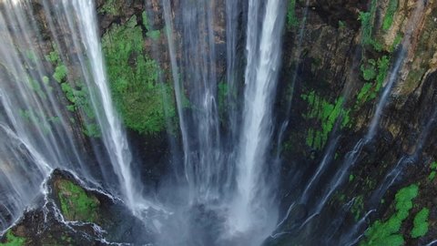 Beautiful view of valley with powerful river and streams flowing and falling down. Aerial view of Tumpak Sewu waterfall in Indonesia.