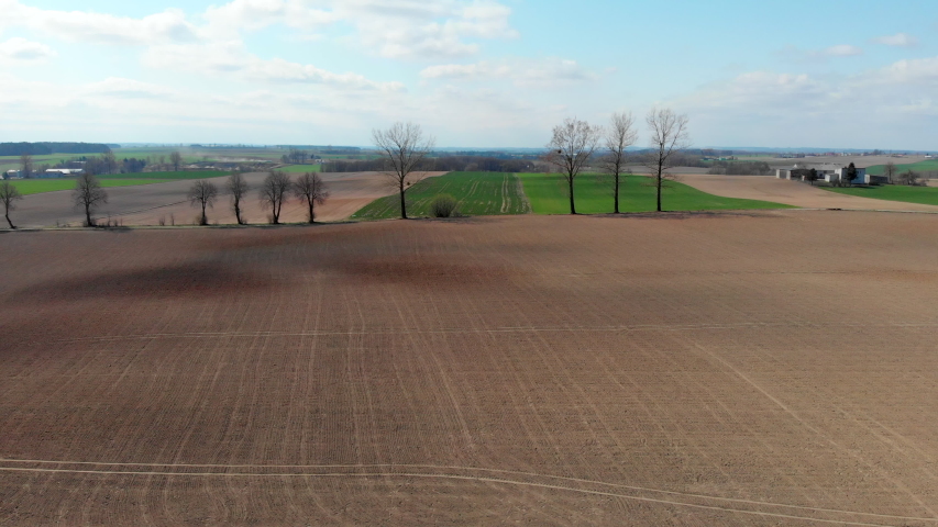 Panoramic shot of farmland with a trees, Panoramic shot of green and brown fields with a trees, Panoramic shot of plowed fields with a trees