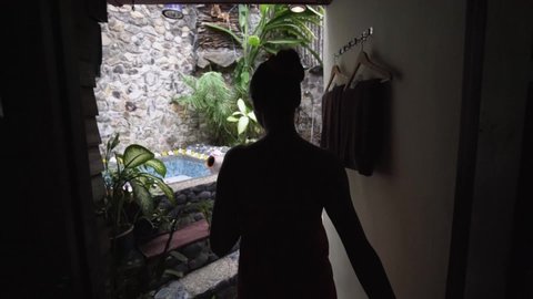 Beautiful Sexy Lady Coming into Tropical Wellness Spa in Bali. Hot Bath with Flowers. Concept: Spa, Treatment, Relaxation, Sensual. Slow Motion