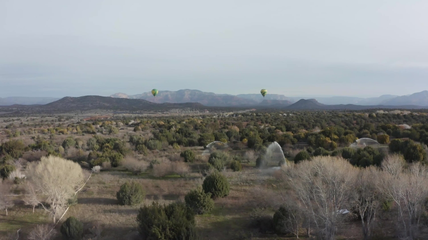 Aerial of Hot Air Balloons in Sedona Arizona with Irrigating Sprinklers and Desert Landscape in Foreground