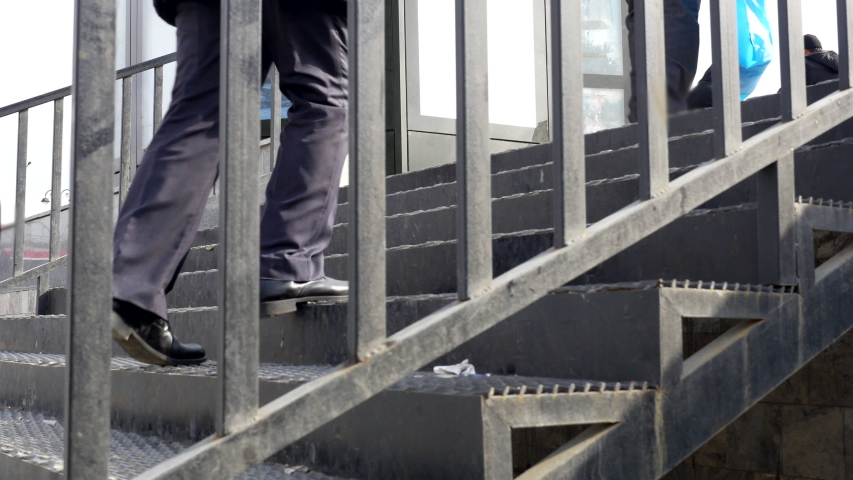 People using stairs for pedestrians in a busy city