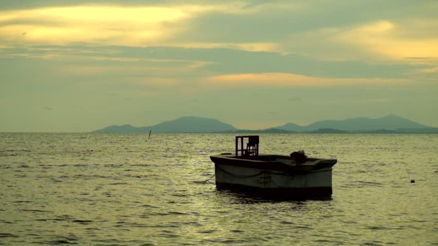 Sea and boat alone at evening with sunset