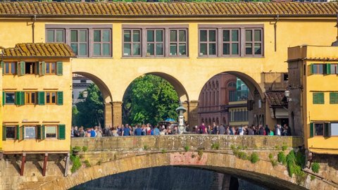 Florence, Tuscany, Italy. Time lapse of The Ponte Vecchio ("Old Bridge") is a medieval stone closed-spandrel segmental arch bridge over the Arno River. Zoom effect