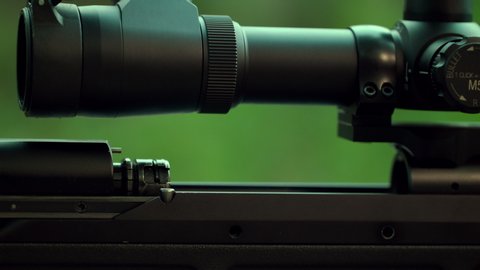 Spectacular shot of a sniper rifle. Hitting the target. The shooter will send the cartridge to the chamber. Shot at the target. Sniper performs a special operation. Slow Motion. 4K. UHD.