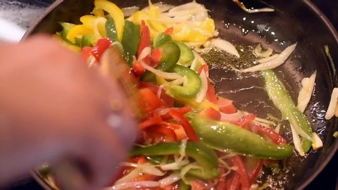 filling for fajitas being cooked on the pan and moved with a wooden spoon
