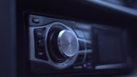 Man's Hand Tuning Radio In The Car