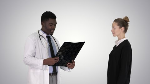Physician showing a patient the X-ray results Then patient leaves on gradient background.