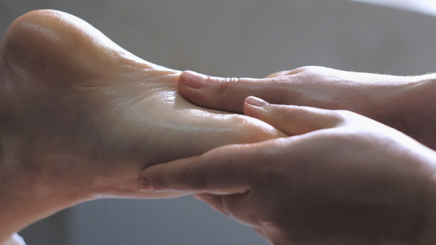 Professional massage therapist does a foot massage to a young woman. | Shutterstock HD Video #1029713105