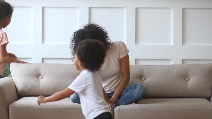 Upset crying african american single mother feeling stressed depressed about active noisy children running around, exhausted tired sad young black mom frustrated with difficult kids having headache Royalty-Free Stock Footage #1029713945
