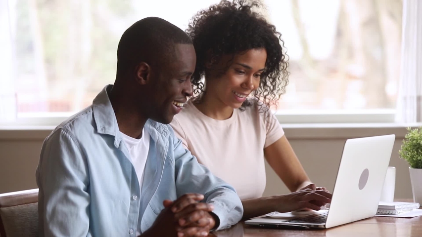 Euphoric happy overjoyed young african american family couple looking at laptop computer feel winners excited by online lottery bid win celebrate good internet news victory achieved new opportunity Royalty-Free Stock Footage #1029714074