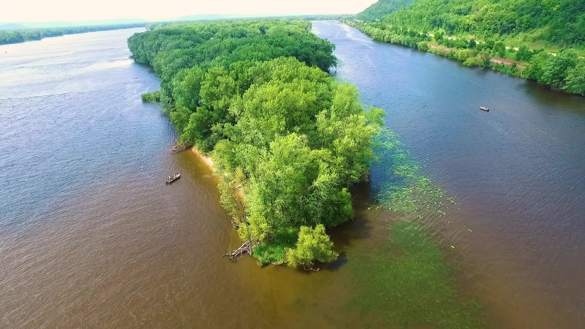 2 fishing boats on each side of an island in the Mississippi River looking for the big catch of the day