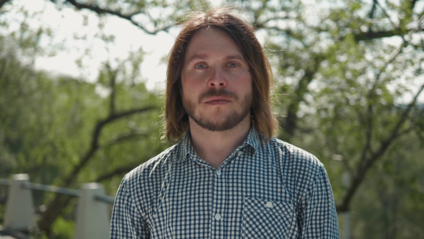 Stylish male tourist with backpack looking to cityscape on the embankment, man on vacation outdoor