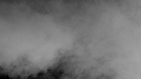 White Smoke Crawls on a Black Screen. A cloud of white smoke slides over the black screen and gradually covers it