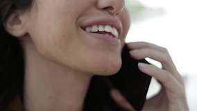 Cropped shot of happy woman talking by cell phone. Close-up partial view of cheerful young woman talking by smartphone, handheld shot. Communication concept