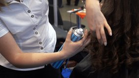 Hairdresser sprays lacquer on a woman's hair. HD video