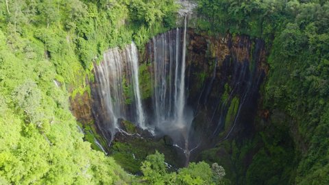 Beautiful aerial landscape of Tumpak Sewu waterfall or Coban Sewu waterfall with Mount Semeru background. Shot in 4k resolution from a drone flying forwards