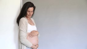 Pregnant woman looking at her belly, isolated