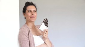 Pregnant woman craving for chocolate bar, isolated
