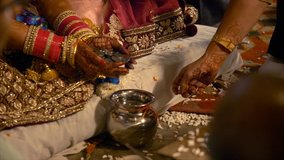 4K stock footage of the Indian bride performing a wedding ritual. Indian stock video of a bride wearing red bangles / chura performing a ritual on her wedding