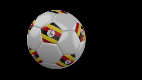 Soccer ball with flag Uganda flies past camera, slow motion blur, 4k footage with alpha channel