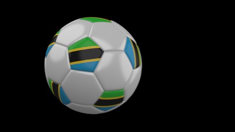 Soccer ball with flag Tanzania flies past camera, slow motion blur, 4k footage with alpha channel