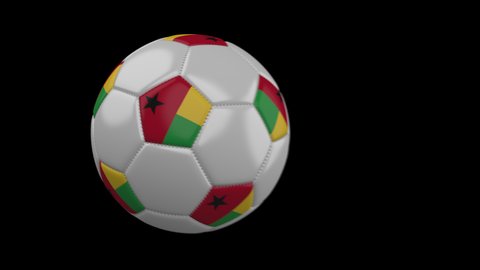 Soccer ball with flag Guinea Bissau flies past camera, slow motion blur, 4k footage with alpha channel